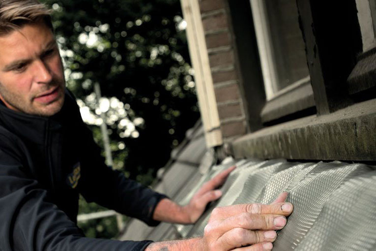 Man aan het werk op een dak met Leadax