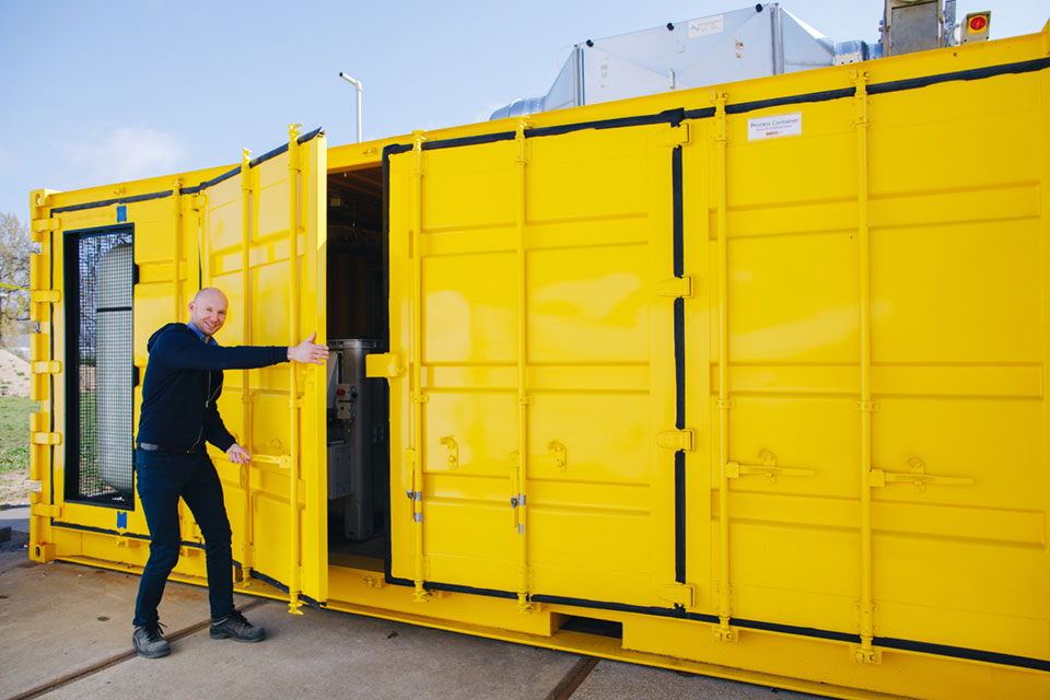 Thijs bij een grote gele container